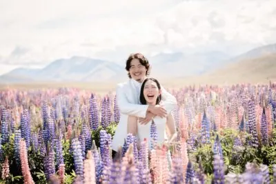 Kyoto Tokyo Japan Elopement Wedding Photographer, Planner & Videographer | A queenstown wedding photographer captures the beautiful moment of a bride and groom embracing in a field of lupines.