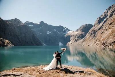 Kyoto Tokyo Japan Elopement Wedding Photographer, Planner & Videographer | Ayaka Morita's portfolio showcasing a bride and groom standing in front of a lake in New Zealand.