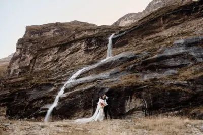 Kyoto Tokyo Japan Elopement Wedding Photographer, Planner & Videographer | Ayaka Morita's portfolio contains a stunning photograph of a bride and groom standing in front of a picturesque waterfall.