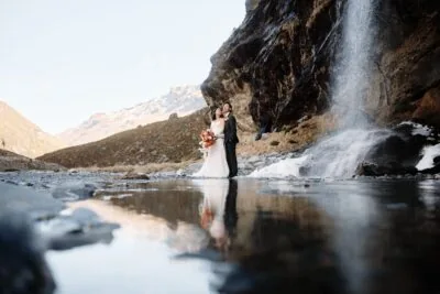 Kyoto Tokyo Japan Elopement Wedding Photographer, Planner & Videographer | Ayaka Morita's portfolio showcases a stunning photograph of a bride and groom captured in front of a mesmerizing waterfall.