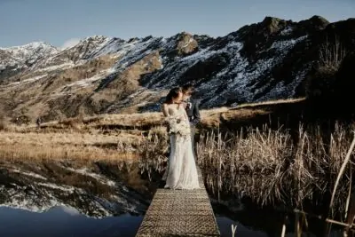 Kyoto Tokyo Japan Elopement Wedding Photographer, Planner & Videographer | Ayaka Morita's portfolio captures a bride and groom standing on a dock near a lake in New Zealand.