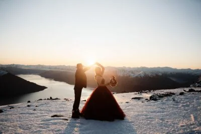 Kyoto Tokyo Japan Elopement Wedding Photographer, Planner & Videographer | Ayaka Morita's portfolio showcases an enchanting image of a bride and groom standing on top of a snowy mountain at sunset.