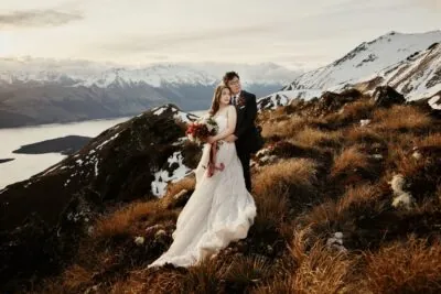 Kyoto Tokyo Japan Elopement Wedding Photographer, Planner & Videographer | Portfolio: A captivating photograph featuring Ayaka Morita capturing a majestic moment of a bride and groom atop a breathtaking mountain in New Zealand.