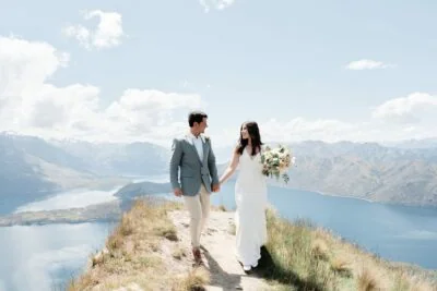 Kyoto Tokyo Japan Elopement Wedding Photographer, Planner & Videographer | Ayaka Morita's portfolio showcases a stunning image of a bride and groom standing on a hill overlooking Lake Wanaka.