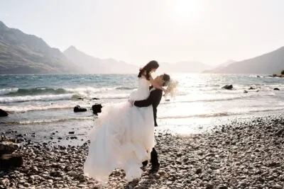 Kyoto Tokyo Japan Elopement Wedding Photographer, Planner & Videographer | Ayaka Morita's portfolio showcases a beautiful moment captured by the shore of Lake Wanaka, where a bride and groom share a warm embrace.