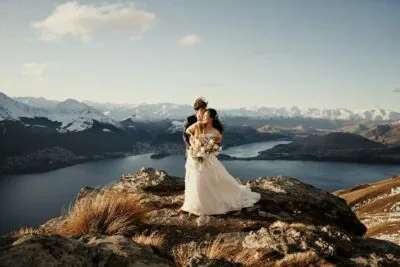 Kyoto Tokyo Japan Elopement Wedding Photographer, Planner & Videographer | An awe-inspiring portfolio photograph capturing a bride and groom on top of a mountain, with Lake Wanaka as the breathtaking backdrop.