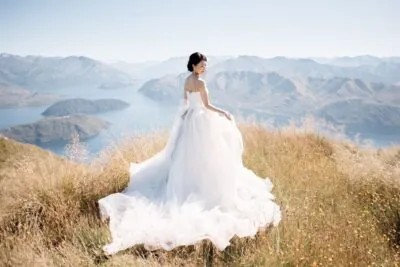 Kyoto Tokyo Japan Elopement Wedding Photographer, Planner & Videographer | Ayaka Morita, a bride in a wedding dress, standing on top of a hill overlooking Lake Wanaka for her portfolio.