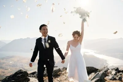 Kyoto Tokyo Japan Elopement Wedding Photographer, Planner & Videographer | Ayaka Morita's portfolio showcasing a beautiful scene of a bride and groom walking down a mountain, with confetti thrown at them.