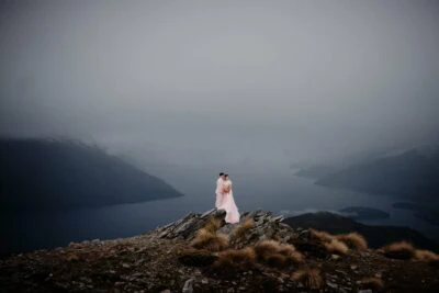 Kyoto Tokyo Japan Elopement Wedding Photographer, Planner & Videographer | Ayaka Morita standing on top of a mountain overlooking Lake Wanaka, showcased in her portfolio.
