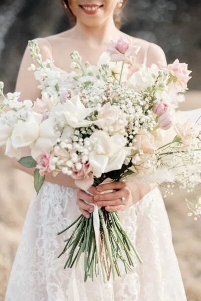 Kyoto Tokyo Japan Elopement Wedding Photographer, Planner & Videographer | Ayaka Morita, a bride in a white dress, showcasing her stunning bouquet of flowers in her portfolio.