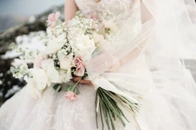 Kyoto Tokyo Japan Elopement Wedding Photographer, Planner & Videographer | Ayaka Morita's portfolio showcases a stunning bride in a wedding dress holding a bouquet amidst the serene snowscape.