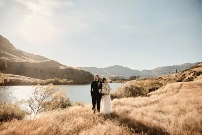 Kyoto Tokyo Japan Elopement Wedding Photographer, Planner & Videographer | Ayaka Morita's portfolio features a beautiful image of a bride and groom standing in the grass near a lake.