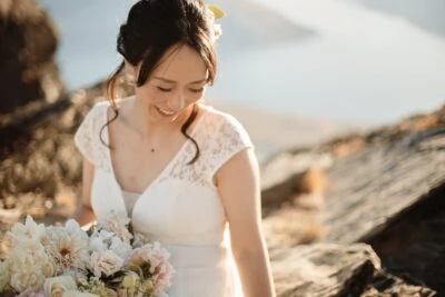 Kyoto Tokyo Japan Elopement Wedding Photographer, Planner & Videographer | Ayaka Morita holding a bouquet on top of a mountain as part of her portfolio.