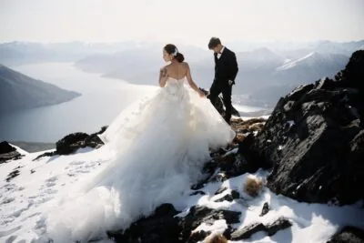 Kyoto Tokyo Japan Elopement Wedding Photographer, Planner & Videographer | Ayaka Morita's portfolio showcases a bride and groom standing on top of a snowy mountain in Queenstown, New Zealand.