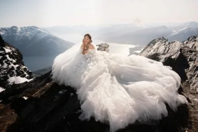 Kyoto Tokyo Japan Elopement Wedding Photographer, Planner & Videographer | Ayaka Morita's portfolio showcasing a bride in a wedding dress sitting on top of a mountain.