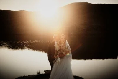 Kyoto Tokyo Japan Elopement Wedding Photographer, Planner & Videographer | Portfolio: A stunning showcase by Ayaka Morita capturing the enchanting moment of a bride and groom standing in front of a beautiful lake at sunset.
