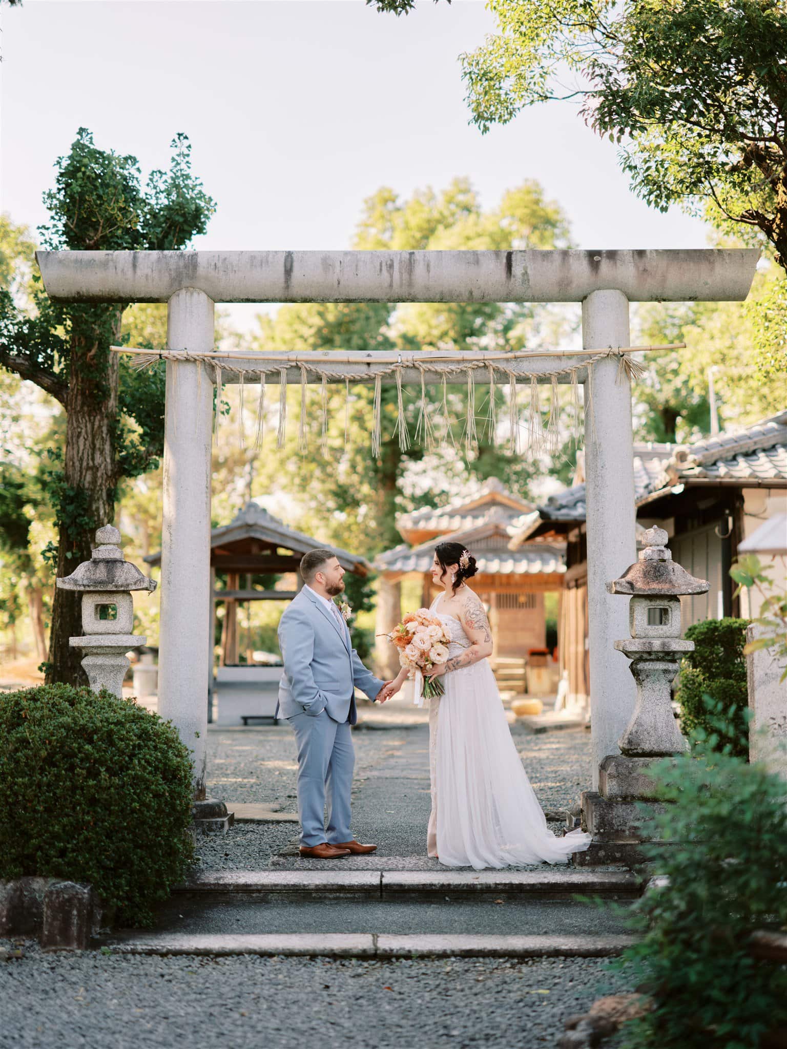 Japan Elopement Wedding Photographer, Planner & Videographer | A couple having a romantic elopement in front of a Japanese torii gate.