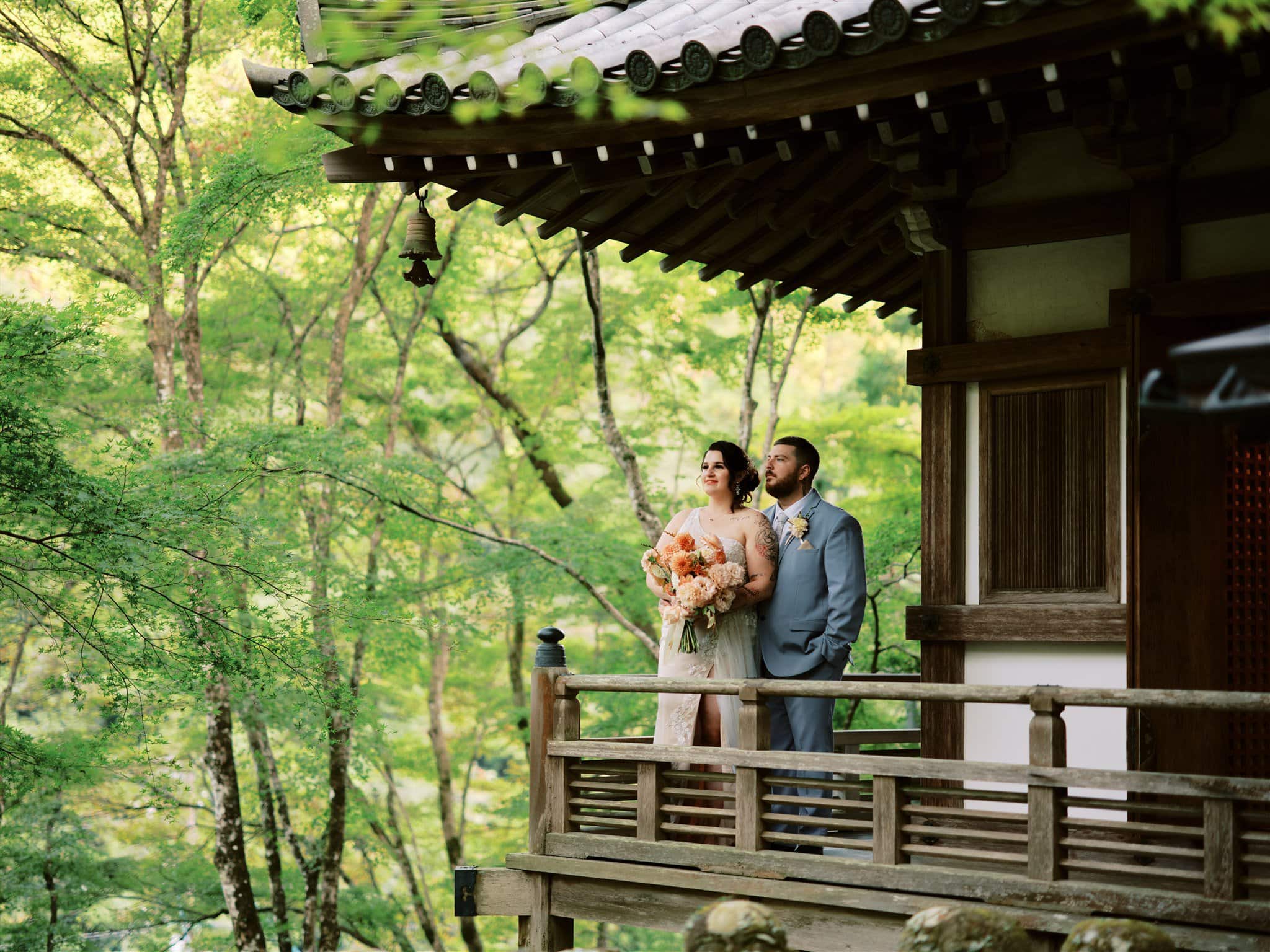 Kyoto Tokyo Japan Elopement Wedding Photographer, Planner & Videographer | A couple in wedding attire, embracing each other on the balcony of a beautiful Japanese house. The scene captures the essence of a romantic Japan elopement, beautifully documented by a talented photographer.