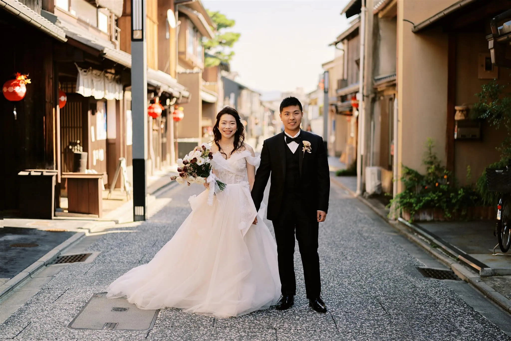 Kyoto Tokyo Japan Elopement Wedding Photographer, Planner & Videographer | A bride and groom strolling down a charming narrow alleyway captured by a skilled Japan elopement photographer.