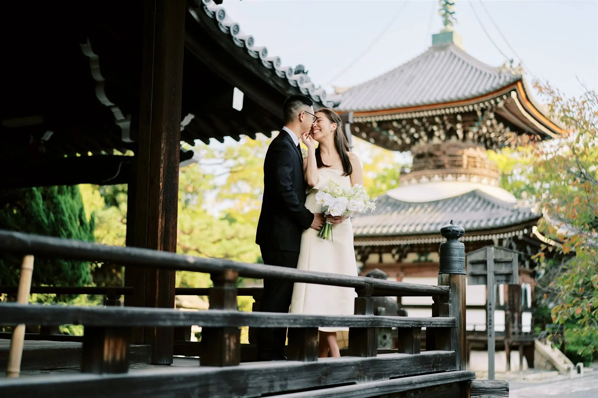 Kyoto Tokyo Japan Elopement Wedding Photographer, Planner & Videographer | A bride and groom kiss in front of a pagoda during their enchanting Japan elopement.