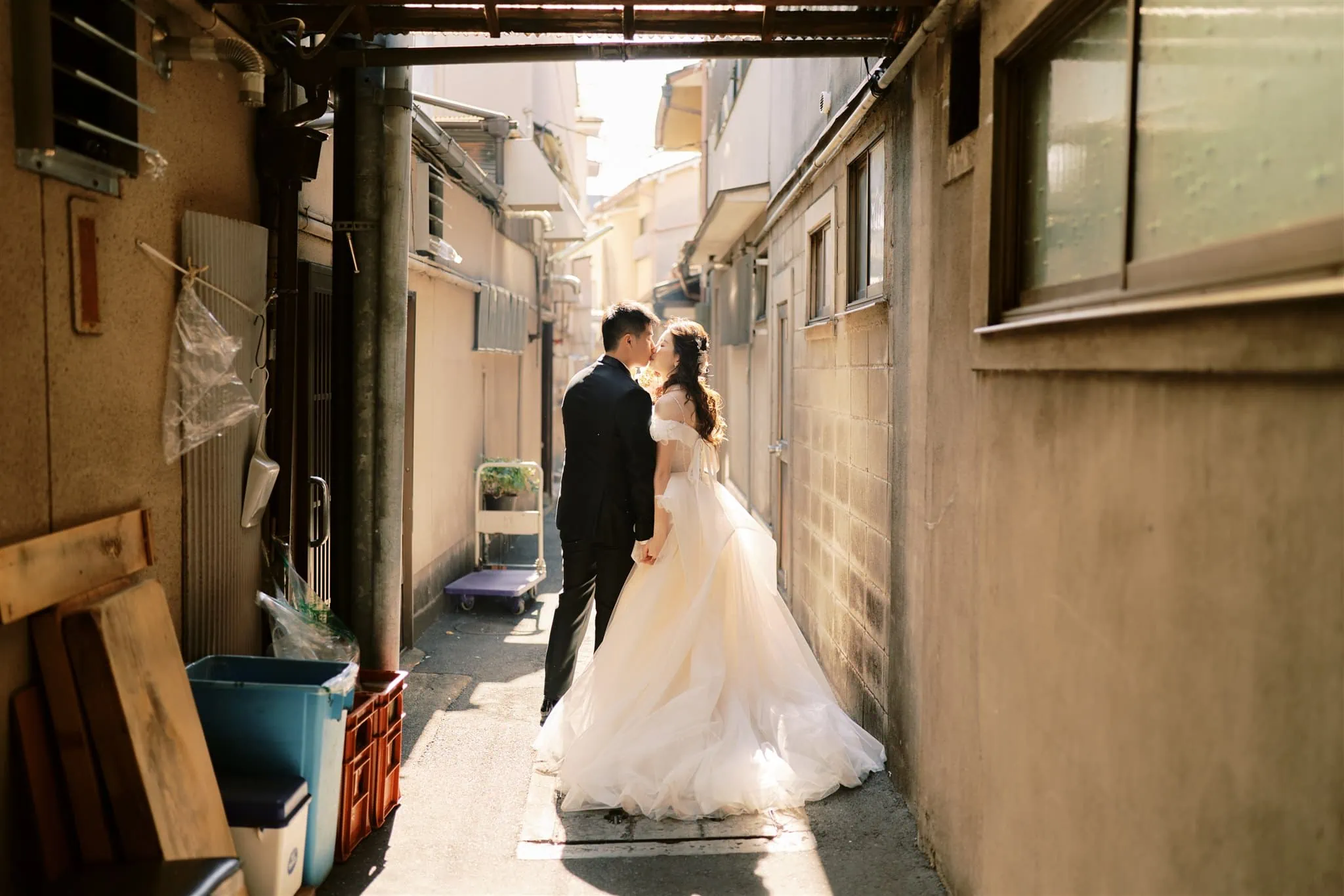 Kyoto Tokyo Japan Elopement Wedding Photographer, Planner & Videographer | A Japan elopement photographer captures an intimate moment between a bride and groom as they share a passionate kiss in an enchanting alleyway.