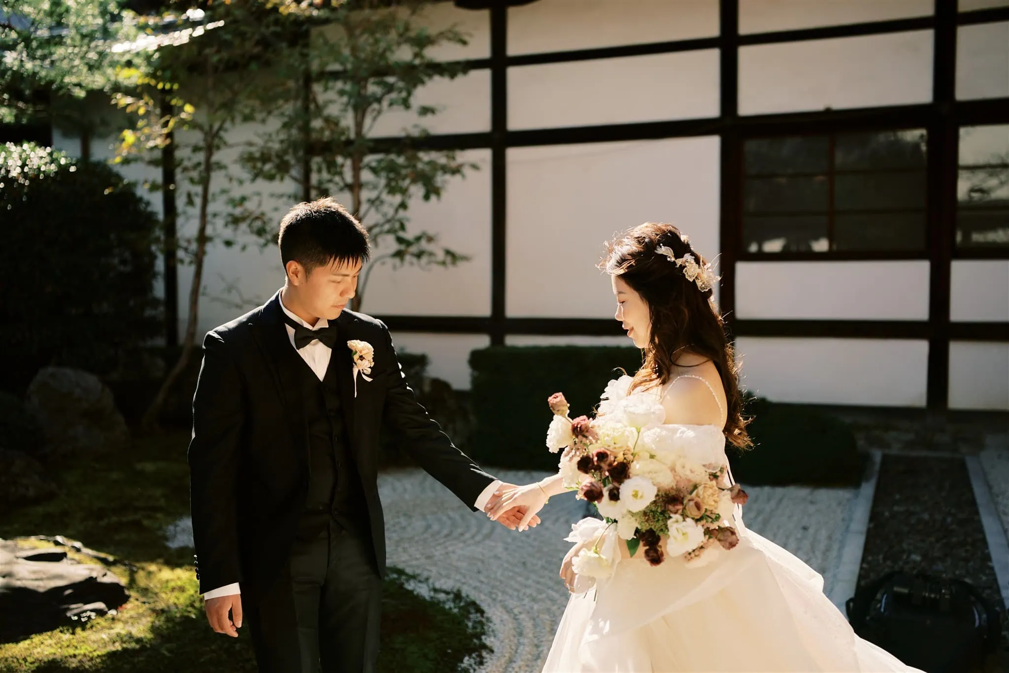 Kyoto Tokyo Japan Elopement Wedding Photographer, Planner & Videographer | A bride and groom holding hands in front of a traditional Japanese house, captured beautifully by a Japan elopement photographer.