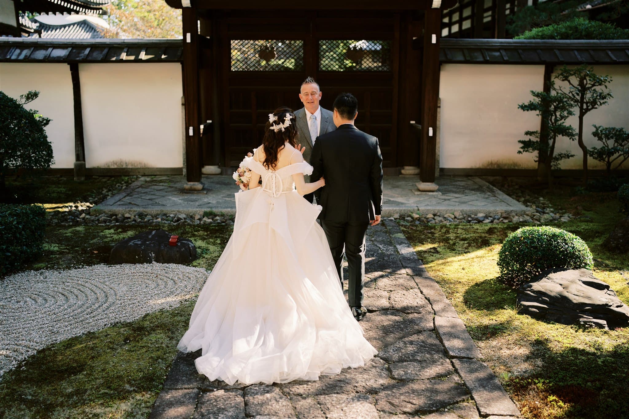 Kyoto Tokyo Japan Elopement Wedding Photographer, Planner & Videographer | A Japan elopement photographer captures beautiful moments of a bride and groom walking through a serene Japanese garden.