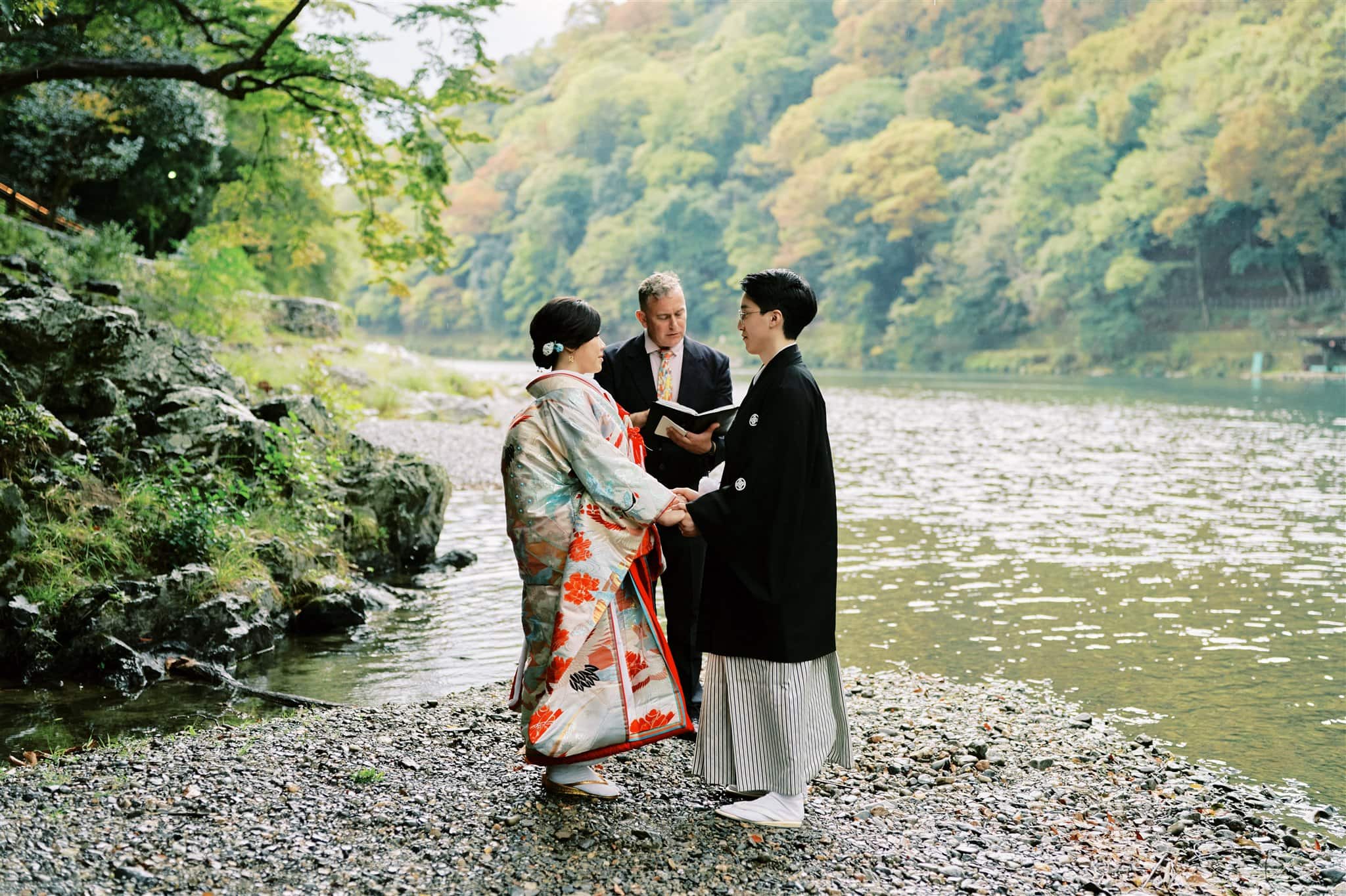 Kyoto Tokyo Japan Elopement Wedding Photographer, Planner & Videographer | Elopement Photographer capturing two people in kimono standing next to a river.