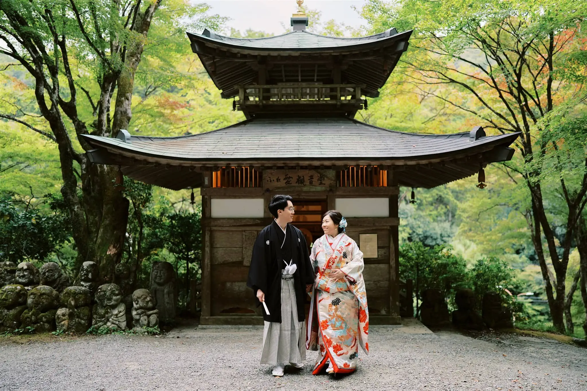 Kyoto Tokyo Japan Elopement Wedding Photographer, Planner & Videographer | An elopement photographer captures a Japanese couple standing elegantly in front of a pagoda.