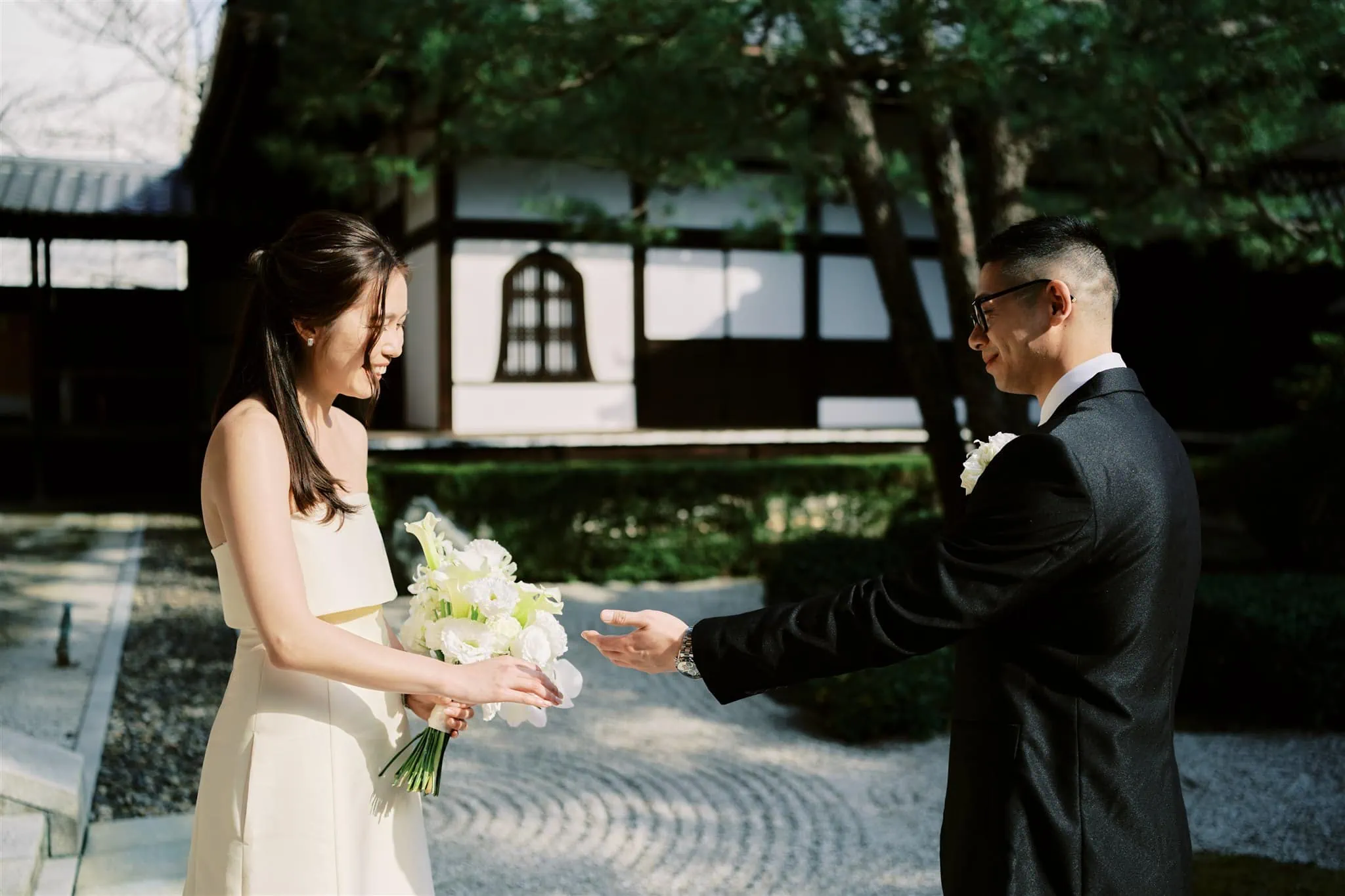 Kyoto Tokyo Japan Elopement Wedding Photographer, Planner & Videographer | A bride and groom are exchanging a gift in a serene Japanese garden during their elopement in Japan.