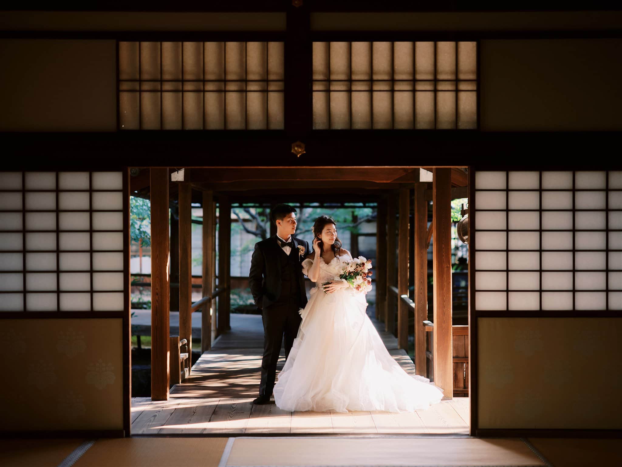 Kyoto Tokyo Japan Elopement Wedding Photographer, Planner & Videographer | A bride and groom elegantly standing in the doorway of a traditional Japanese house, captured beautifully by a talented Japan elopement photographer.