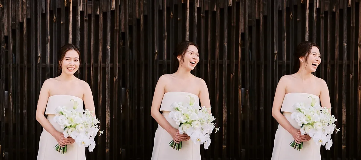 Kyoto Tokyo Japan Elopement Wedding Photographer, Planner & Videographer | A bride in a white dress holding a bouquet in front of a wooden fence during her Japan elopement.