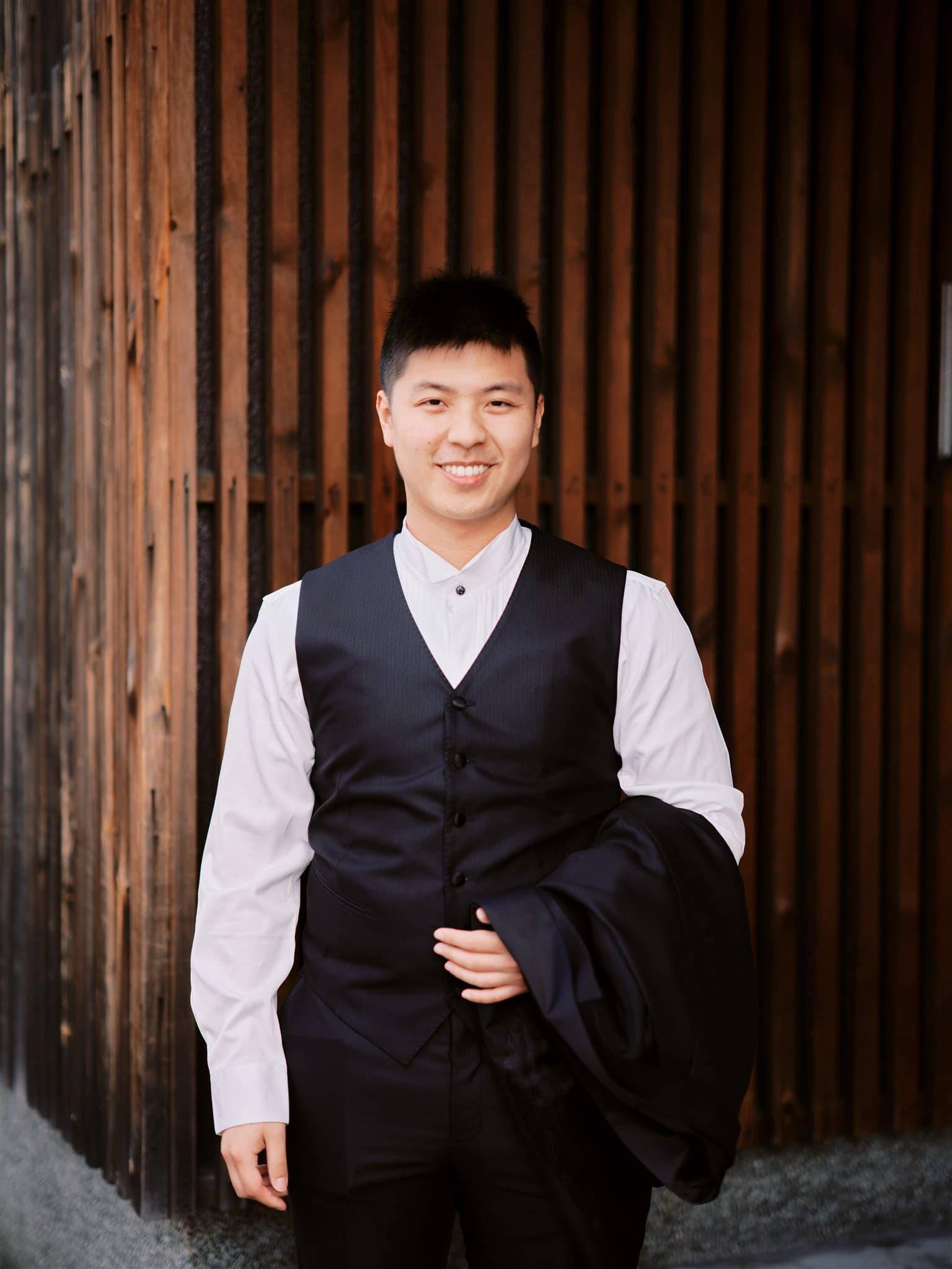 Kyoto Tokyo Japan Elopement Wedding Photographer, Planner & Videographer | A young man in a black vest and white shirt, capturing romantic moments as a Japan elopement photographer.