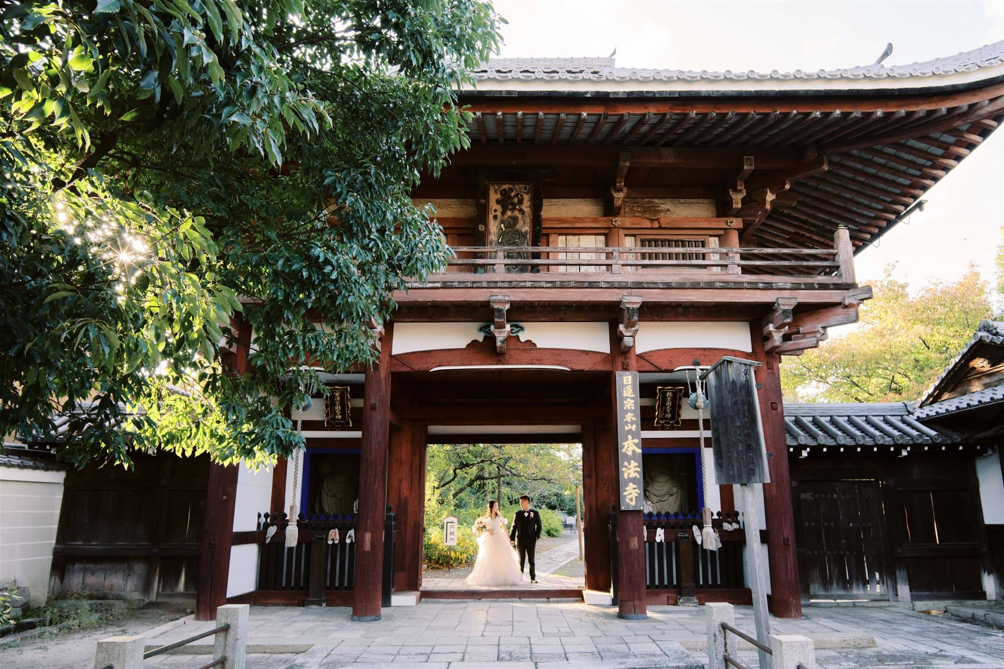 Kyoto Tokyo Japan Elopement Wedding Photographer, Planner & Videographer | A bride and groom, following the latest wedding trends, stand at the entrance of a traditional Japanese temple.