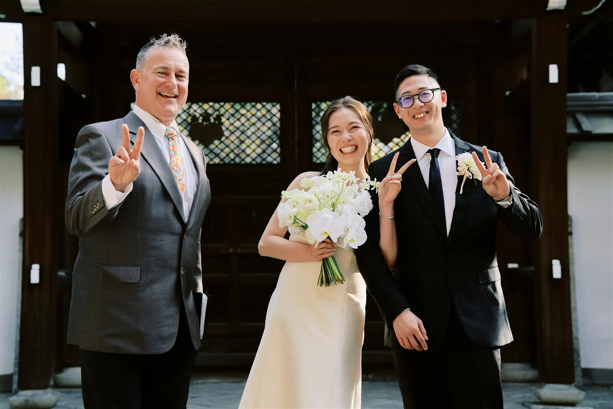 Kyoto Tokyo Japan Elopement Wedding Photographer, Planner & Videographer | A bride and groom elope to Japan, where they pose for a photo in front of a temple.