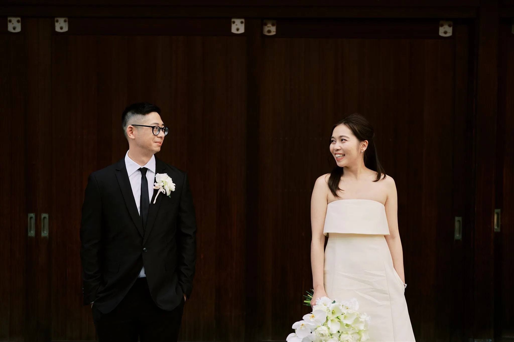Kyoto Tokyo Japan Elopement Wedding Photographer, Planner & Videographer | A Japan elopement - a bride and groom standing in front of a wooden door.