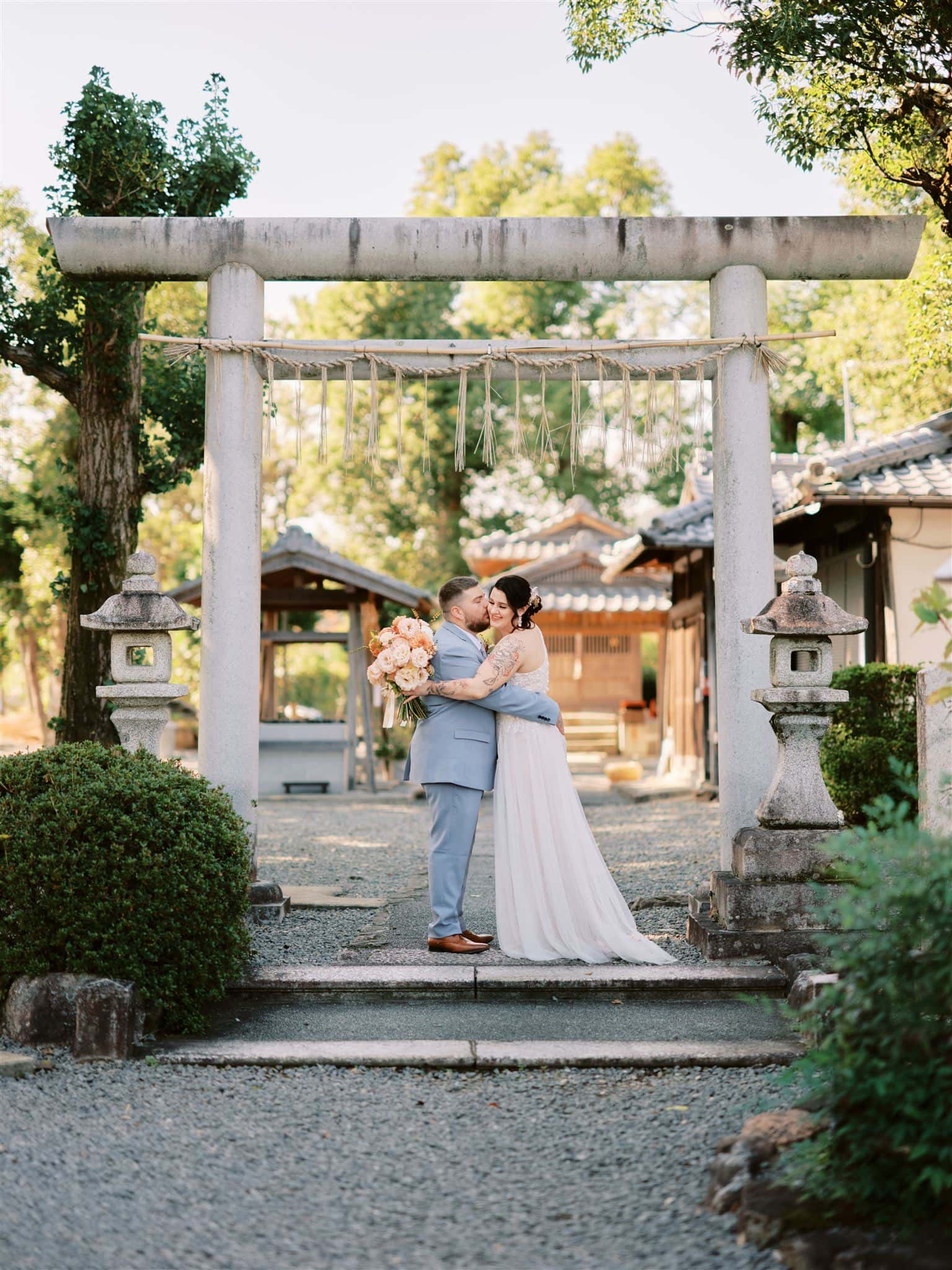 Japan Elopement Wedding Photographer, Planner & Videographer | A Queenstown Heli-Wedding & Elopement Package capturing a breathtaking moment of a bride and groom kissing in front of a Japanese torii gate.