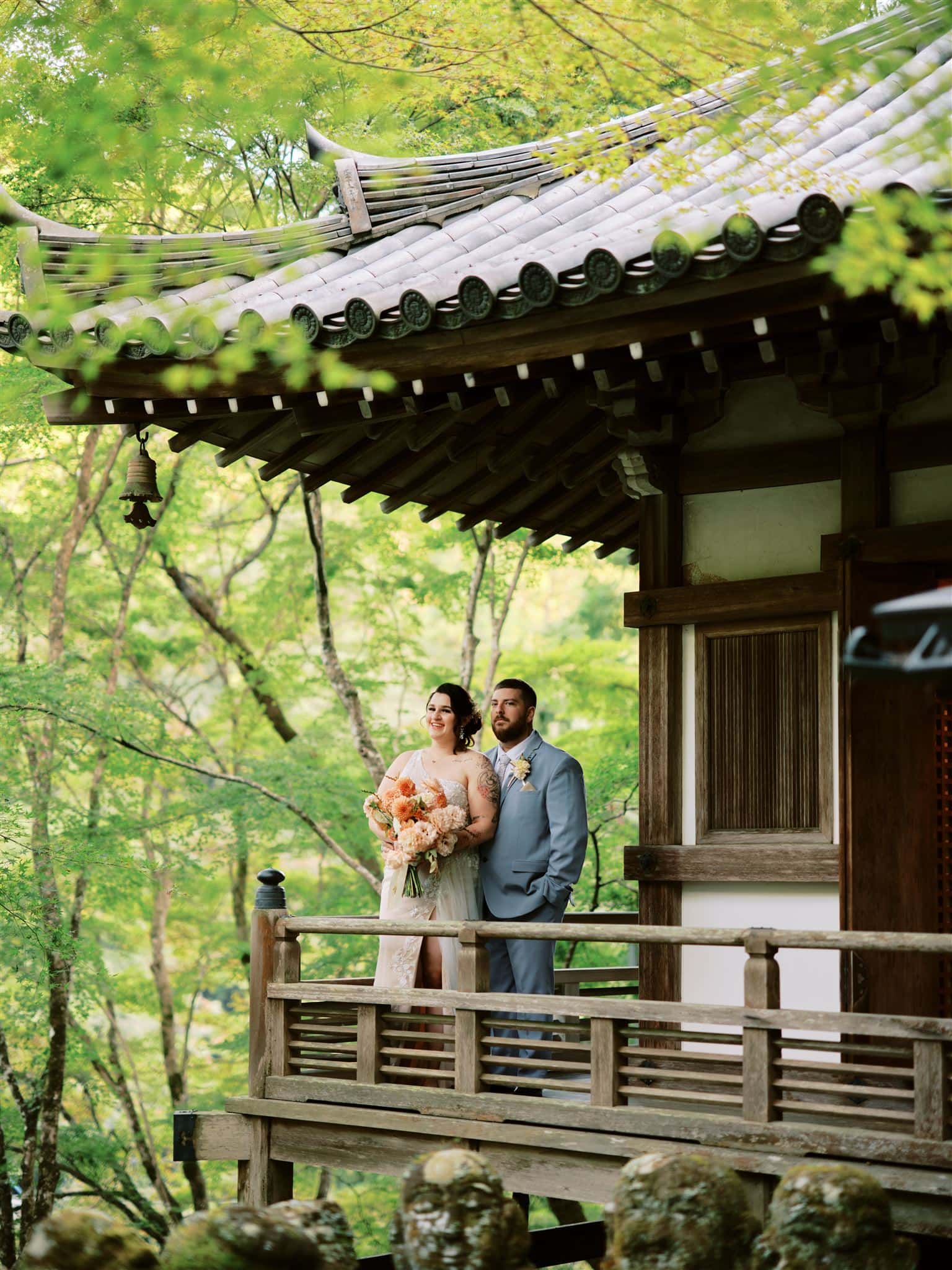 Japan Elopement Wedding Photographer, Planner & Videographer | Kyoto Wedding & Elopement Package featuring a bride and groom standing on the porch of a Japanese temple