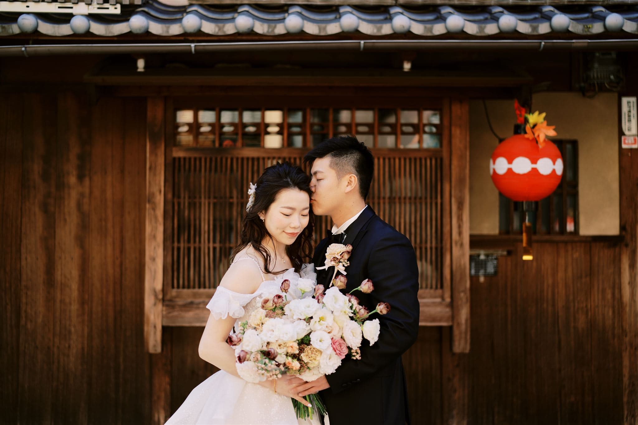 Japan Elopement Wedding Photographer, Planner & Videographer | An Exclusive couple posing in front of a beautiful Japanese house on their Wedding Day.