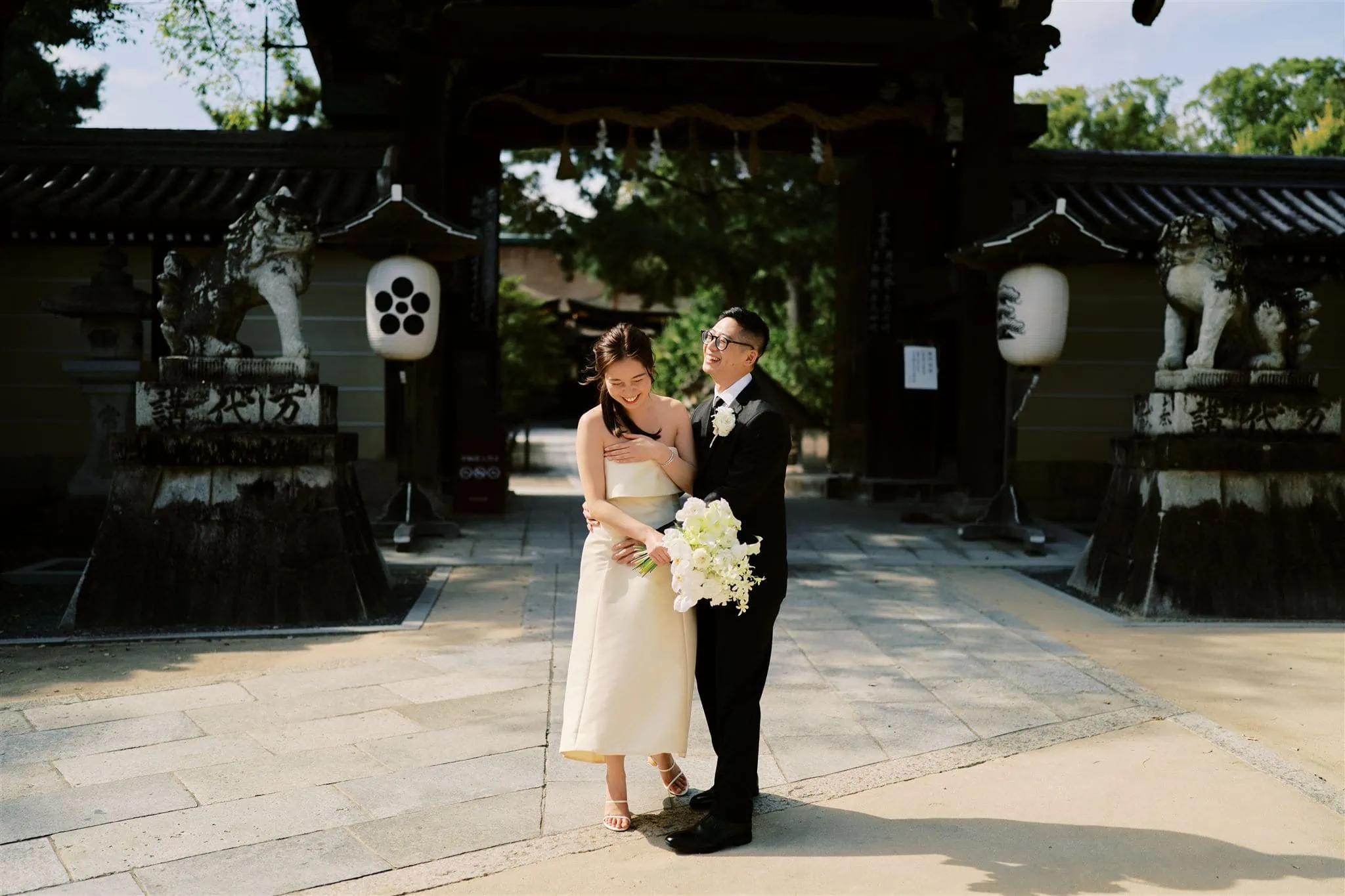 Japan Elopement Wedding Photographer, Planner & Videographer | A bride and groom standing in front of a shrine during their elopement wedding in Kyoto.