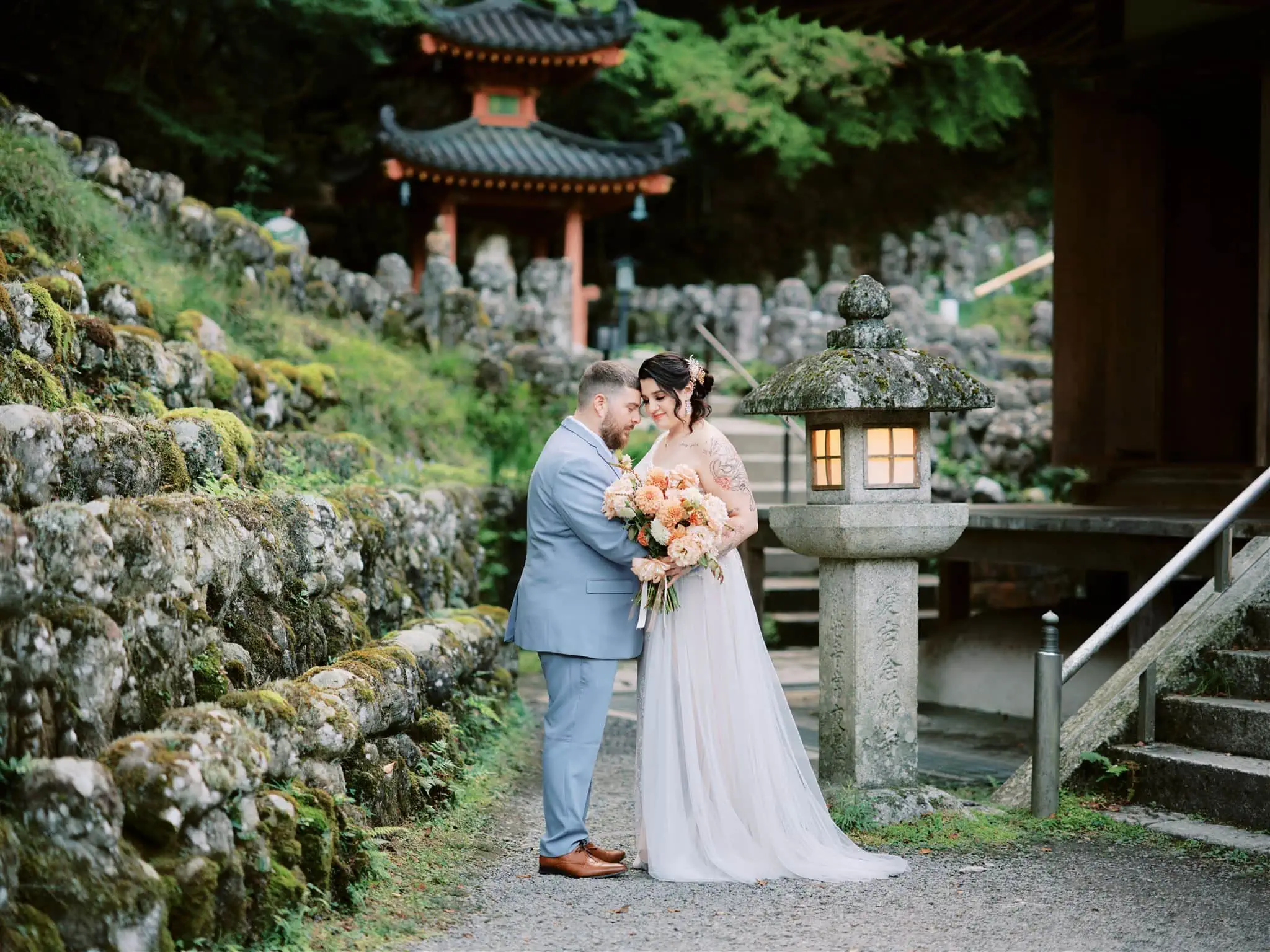 Japan Elopement Wedding Photographer, Planner & Videographer | A bride and groom embracing in front of a Japanese pagoda during their Queenstown Heli-Wedding & Elopement Package.
