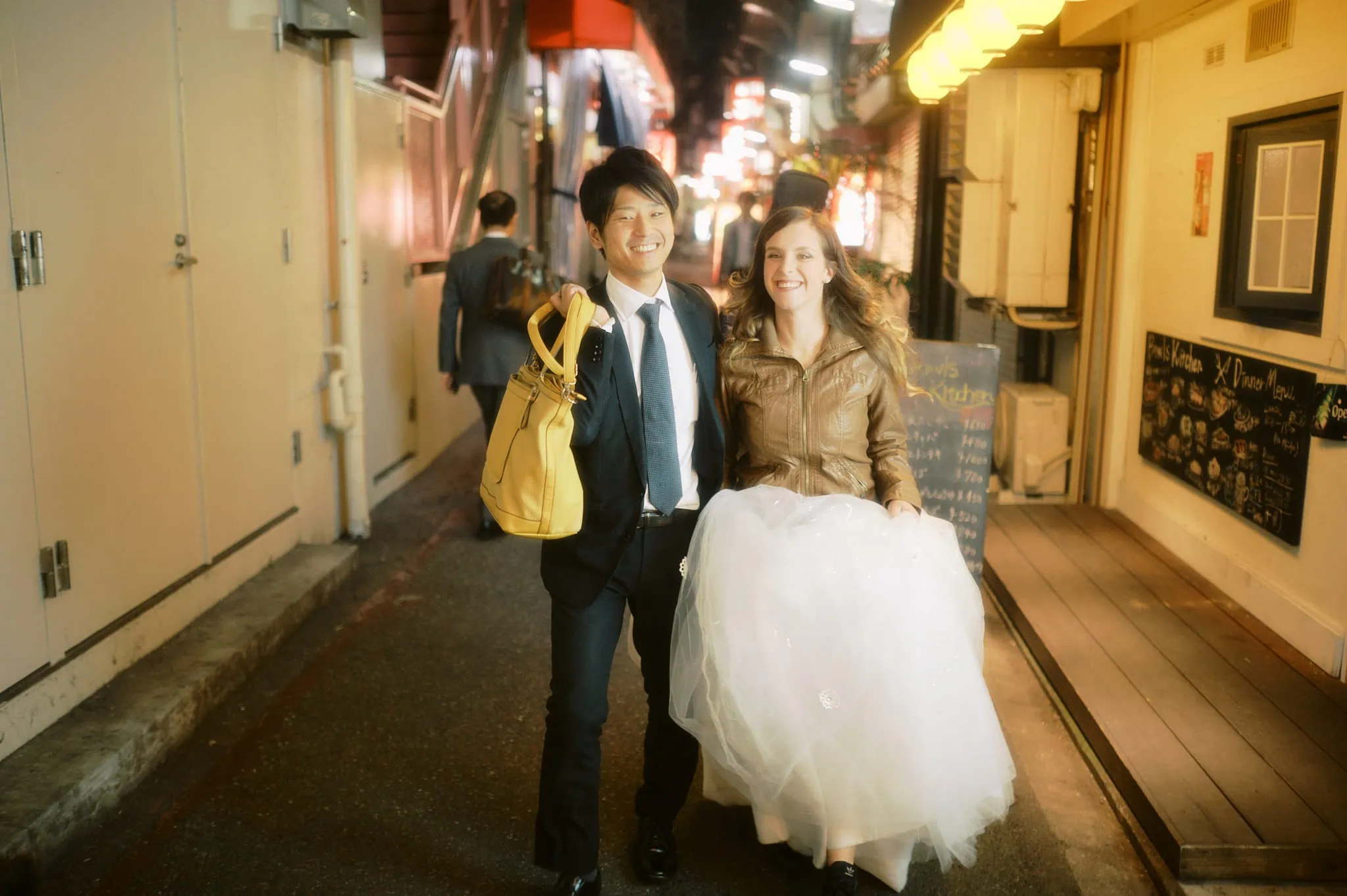 kyoto kobe japan elopement wedding photographer pre-wedding shoot - couple walking in streets of japan with wedding dress and suit